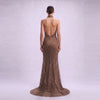 Backless detail and sweeping train of mocha beaded mesh halter formal gown by Cenia New York⁠