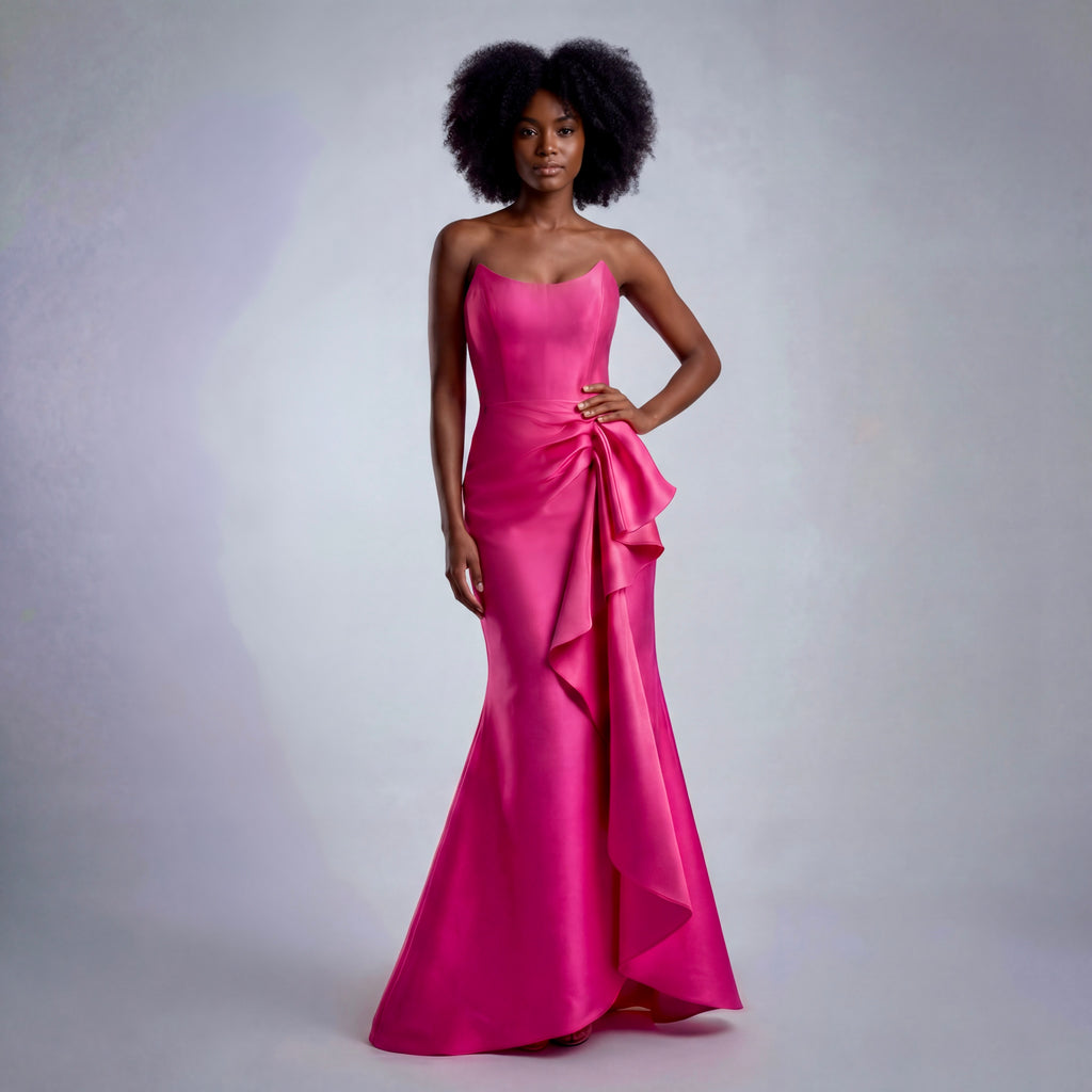 Woman wearing a pink evening gown against a plain background